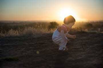 Sunny evening and the first independent steps. Baby's first steps in nature