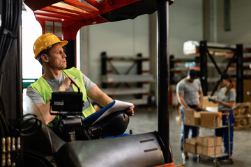 Pensive forklift driver in a distribution warehouse.