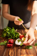 lime strawberry mint ingredients for making lemonade on white plate on wooden table