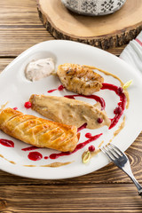 fried fish fillet and pie with mushroom sauce on wooden table
