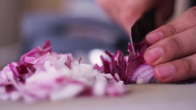 Man hands chopping purple onion in kitchen close-up