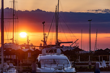 Naklejka na ściany i meble Sunset on a harbour with some boats