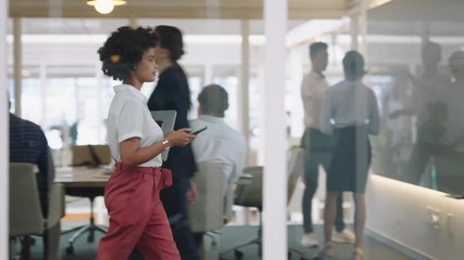 mixed race business woman using smartphone walking through office texting sending emails successful female executive checking messages on mobile phone arriving at busy workplace 4k   - Powered by Adobe