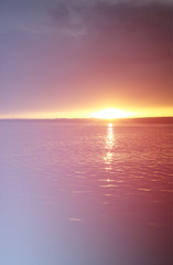 Fototapeta premium Vertical sunset on river with dramatic light leak landscape