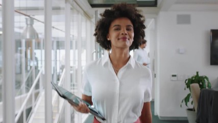 mixed race business woman smiling walking through office holding tablet computer enjoying successful career in corporate workplace 4k   - Powered by Adobe