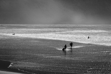 Fototapeta na wymiar Silhouettes of surfers on the shores of the Atlantic Ocean. Beach in the suburbs of Agadir. Africa Morocc
