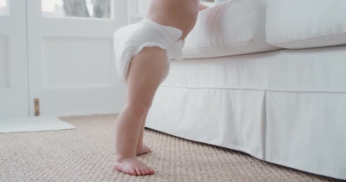 baby legs learning to walk toddler taking first steps wearing diaper cute infant walking at home 4k