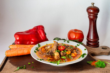 Rich lentil stew with pork and vegetables. On a wooden board.