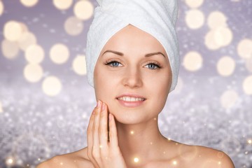 Portrait of beautiful young woman  in white towel on head on white background