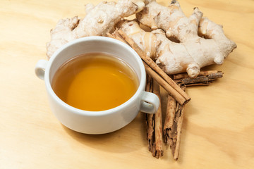 Drink made with ginger root, and cinnamon; photo on wooden background