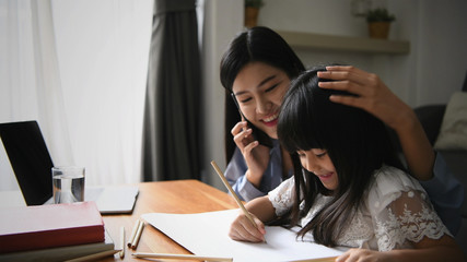 Family concept. Mom is working and taking care of her daughter too.