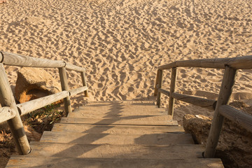 Fototapeta na wymiar Wooden stairs leading to the sand
