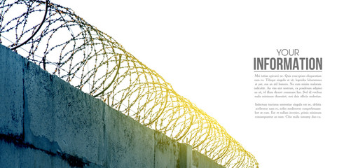 barbed wire on a concrete fence barrier, sample text on blue sky background