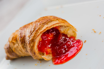 Beautiful croissant with jam on plate