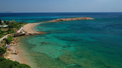 Fototapeta na wymiar Aerial photo of not so famous Akrotiri Lovardas beach and small islet with caves and clear turquoise sea, Athens riviera, Attica, Greece