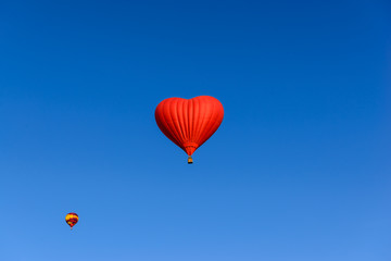 Red heart shaped balloon on the background blue sky.