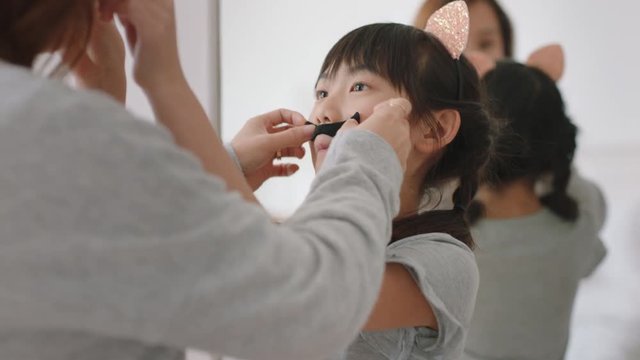 Asian Mother And Daughter Playing Dress Up Game At Home Wearing Cat Ears Little Girl Having Fun With Mom Enjoying Playful Day With Child Together On Weekend Happy Family 4k Footage