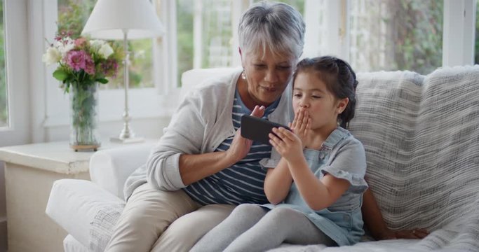 Little Girl Using Smartphone With Grandmother Having Video Chat Waving At Family Sharing Vacation Weekend With Granny Chatting On Mobile Phone Relaxing At Home With Granddaughter 4k