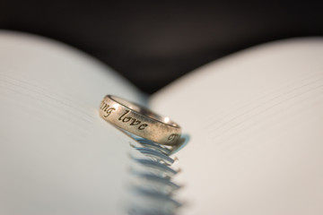 Abstract a pair of two wedding rings engagement on a book page space for text input. concept couple lover pre wedding.