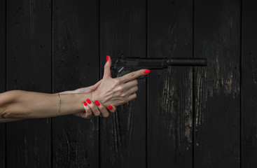 woman's hand with a pistol with a silencer