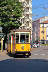 Naklejka premium tram giallo a milano in italia, yellow streetcar in the downtown of milan city in italy 