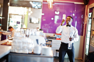 African american bartender at bar flair in action, working behind the cocktail bar. Alcoholic beverage preparation.