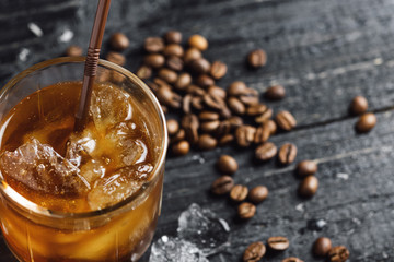 ice coffee in a glass with crushed ice on a dark wooden table