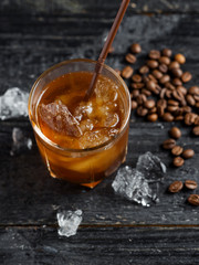 ice coffee in a glass with crushed ice on a dark wooden table
