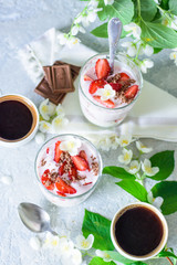 Curd dessert with strawberries and chocolate on the background of flowers and coffee top view