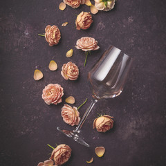Rose wine and roses on dark purple background
