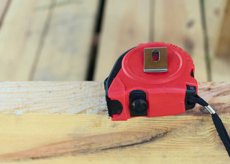 Single red yardstick measurement,  lying on a wooden bar