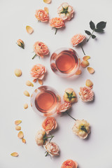 Rose wine and roses on white background