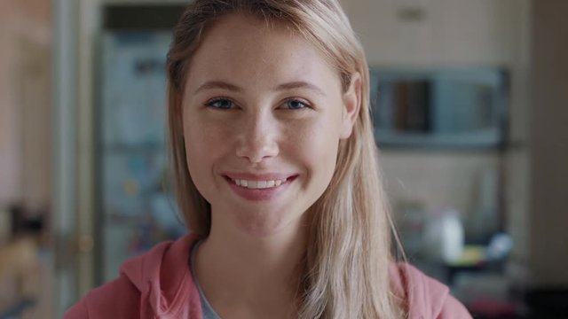 portrait beautiful blonde teenage girl in kitchen at home smiling happy enjoying carefree lifestyle