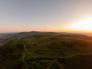 Fototapeta na wymiar Colorful sunset at Cave Hill Country Park Belfast, Northern Ireland. Aerial view on City and hills 