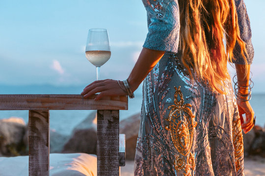 close up of beautiful l fashion model in elegant dress at sunset with glass of wine