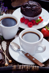 Black coffee in white cups and chocolate muffin for breakfast