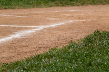 Chalk lines the field with the edge of the fresh grass and baseball base