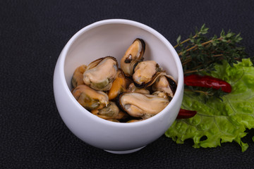 Pickled mussels in the bowl served pepper, garlic and salad