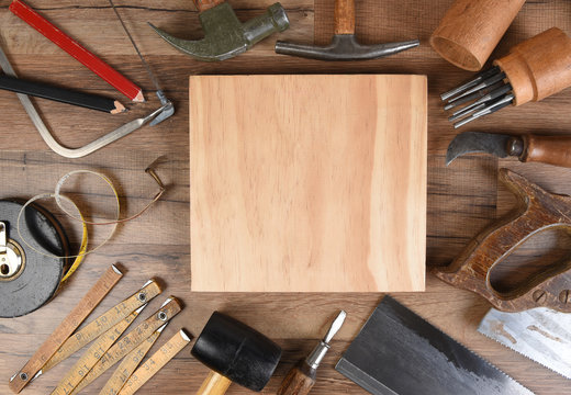 High angle closeup of a large group of tools arranged around an piece of wood, an ideal space for your copy