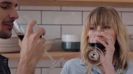 happy young couple cooking together in kitchen preparing dinner drinking wine enjoying healthy lifestyle making toast celebrating relationship at home 4k