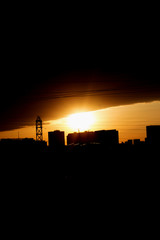 City landscape Golden sunset over the city and black silhouettes of houses