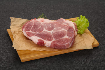 Raw pork steak over wooden board
