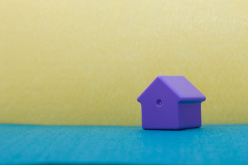 little lilac plastic house on the field/ blue and yellow felt bachground