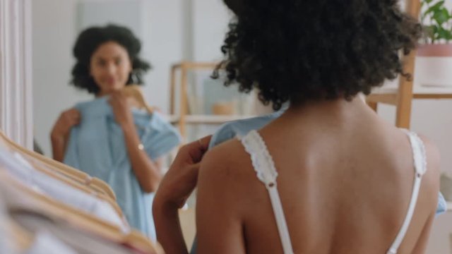 beautiful mixed race woman getting dressed looking in mirror fresh start to new day putting on clothes enjoying morning at home positive self image 4k footage