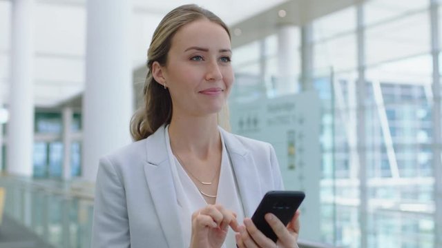 beautiful business woman using smartphone texting walking in corporate office typing text messages on mobile phone checking emails successful female executive at work 4k footage