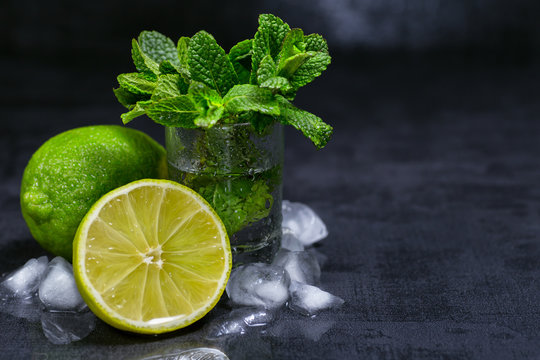 Fresh mint, lime and ice on a black background. Ingredient for mahito