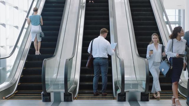 business people on escalators in busy corporate office lobby working nine to five rush 4k footage