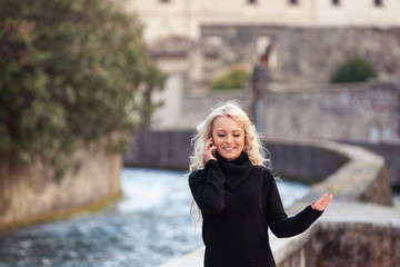Pretty slender young woman talking on her mobile
