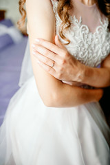 hands of the bride lie on the dress