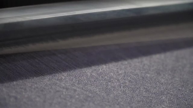 Briliant closeup shot of denim being produced from an automated machine.